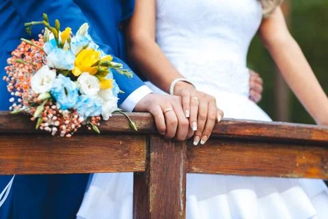 Bride hands with ring and wedding bouquet of flowers Stock Photos