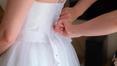 Bride having corset tied on white wedding dress indoors Video stock 342022518