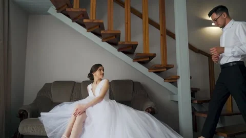 Bride helps groom get dressed and prepare for wedding ceremony. Slow motion Stock Footage 206074995