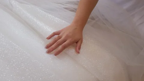 The bride in her hand slides her white wedding dress, close-up shots. Stock Footage 235730616