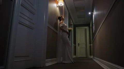 The bride on her wedding day in an elegant wedding dress in the hotel corridor. Stock Footage 292149254
