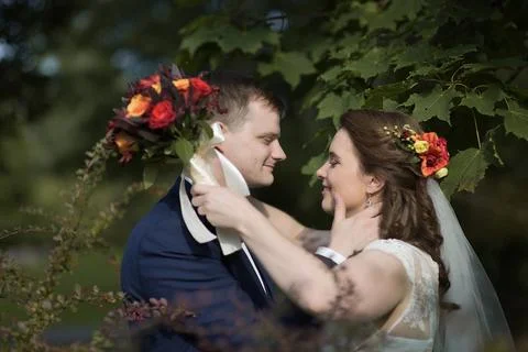 Bride holding bouquet while sharing loving gaze with groom Stock Photos