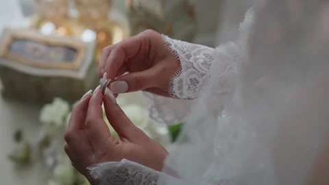 The bride is holding a gold wedding ring in her hands 스톡 동영상 348008341