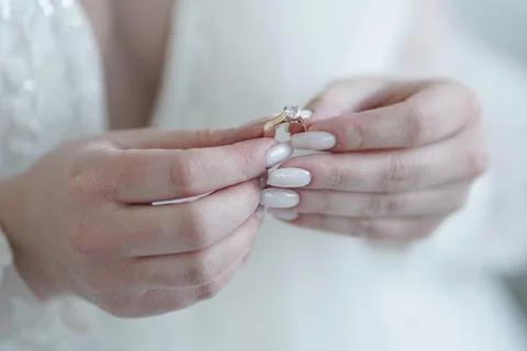 The bride is holding a ring in her hands. Preparation for the wedding. Stock Photos