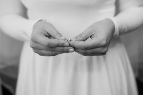 Bride Holding Wedding Ring with Delicate Hands Stock Photos