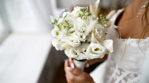 Bride holding white wedding bouquet with lace dress Stock Photos