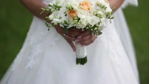 Bride holds the bouquet with both hands and lifts it. Stock Footage 223360817