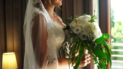 Bride holds a bouquet by the window Vidéo 105697406
