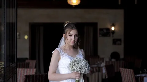 Bride holds white bouquet posing against restaurant interior Stock Footage 119694954