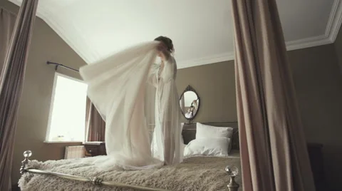 Bride jumping on the bed in the rich interior Stock Footage 67569919