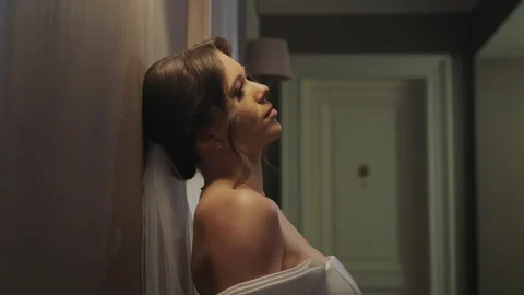 Bride Leaning Against Wall with a Content Smile. A bride leans back against a Stock Footage 284440946