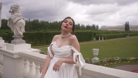The bride leans on the parapet against the backdrop of a beautiful meadow Stock Footage 263059941