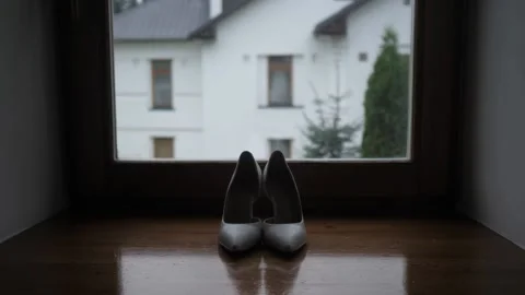 Bride light-colored shoes stand on the wooden windowsill against the background Stock Footage 149646204