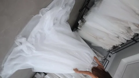 The bride in a long elegant white dress is slowly spinning in the wedding salon. Stock Footage 322042447