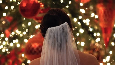 Bride looking at Christmas tree from behind Stock Footage 89443975