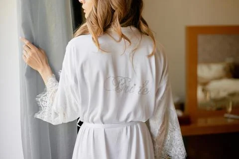 Bride looking ot window at her wedding morning Stock Photos
