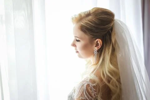 Bride looking out from the window Stock Photos