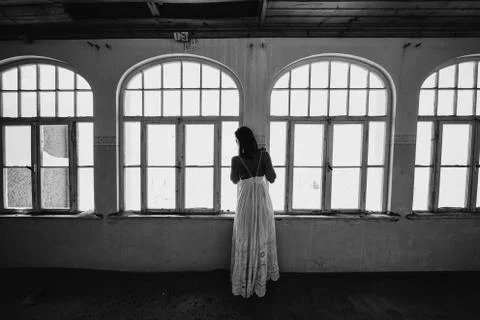 Bride looking outside windows of an old colonial villa Stock Photos