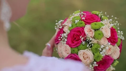 The bride is looking at the wedding bouquet 스톡 동영상 82816485