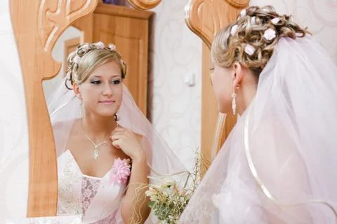 Bride looks in the mirror Stock Photos
