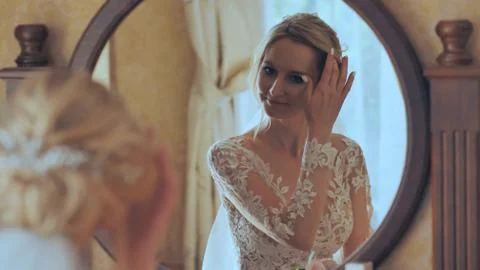 The bride at the mirror is preparing for the wedding. Stock Photos