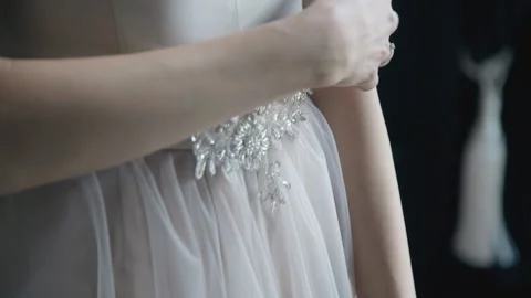 Bride moving her hand across white wedding dress closeup Video stock 119388756