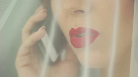 Bride with painted red lips talking on the phone Stock Footage 61926256