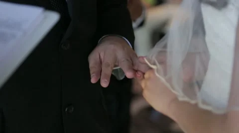 Bride placing ring on grooms finger close up shot Stock Footage 46063228