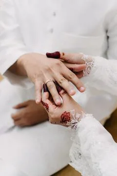 Bride Placing Ring on Groom's Hand with Traditional Henna. Stock-Fotos