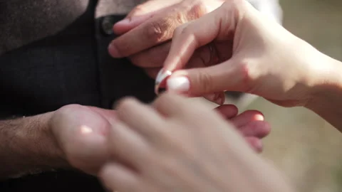Bride placing wedding ring on groom finger Stock Footage 312512893