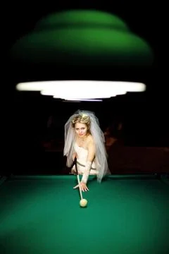 Bride playing billiard at night Stock Photos