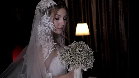 Bride with plump lips and veil poses against lamp light Stock Footage 119761741