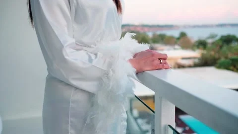 The bride is posing on the balcony in her dressing gown  動画素材 141855565