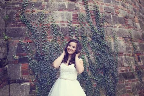 Bride posing on a bricked wall Foto stock