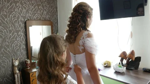 Bride prep - daughter tying laces of wedding dress of mum bride Vídeo Stock 239987175
