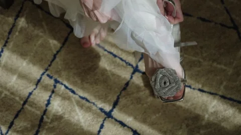 Bride Prepares Quietly, Bride Slipping On Silver Shoes, Soft Light Highlights Stock Footage 323775516