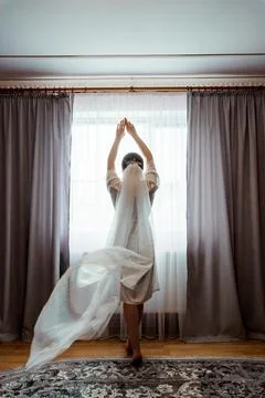 Bride Preparing for Her Wedding Day with Veil Flowing in Soft Light Stock Photos