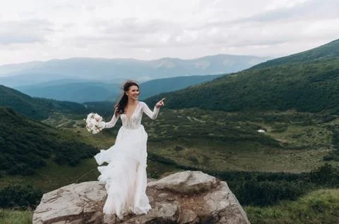 The bride is preparing to throw the bouquet. Bride in the mountains Stock Photos