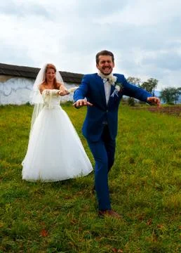 Bride pulling her groom to her with a rope - funny wedding concept Foto stock