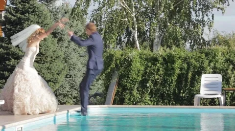 Bride punch groom in swimming pool Stock Footage 44019651