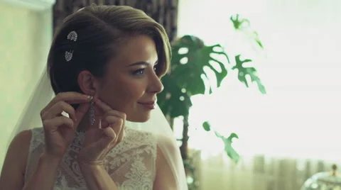 The bride puts on her earrings slow motion Stock Footage 54060328