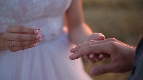 The bride puts the ring on the finger of the groom. Wedding ceremony at sunset. 스톡 동영상 82844238