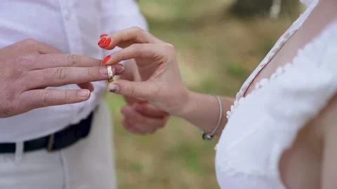 The bride puts the ring on the groom's finger on forest location Stock Footage 204936970