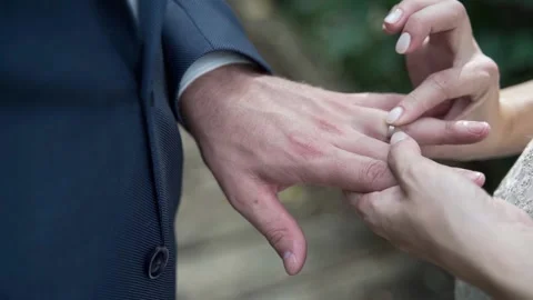 The bride puts the ring on the groom's finger, close-up of hands Stock Footage 239734121