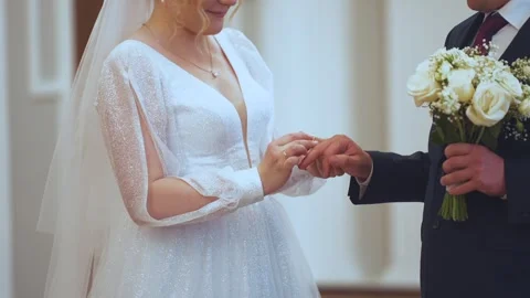 The bride puts a ring on the groom's finger Stock Footage 252858045