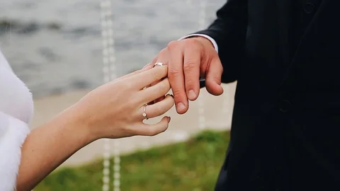 The bride puts a ring on her lover's finger. Close-up of hands. Wedding Stock Footage 123109968
