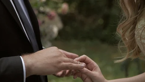 The bride puts the wedding ring on the bride's finger. At the wedding ceremony Stock Footage 111569474