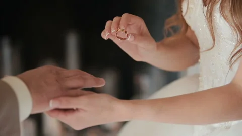 The bride puts the wedding ring on finger of the groom. marriage hands with Stock Footage