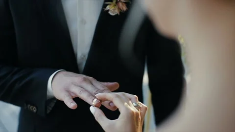 The bride puts the wedding ring on finger of the groom. marriage hands with Stock Footage
