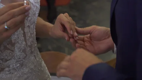The bride puts the wedding ring on finger of the groom, marriage hands with ring Stock Footage 121472079